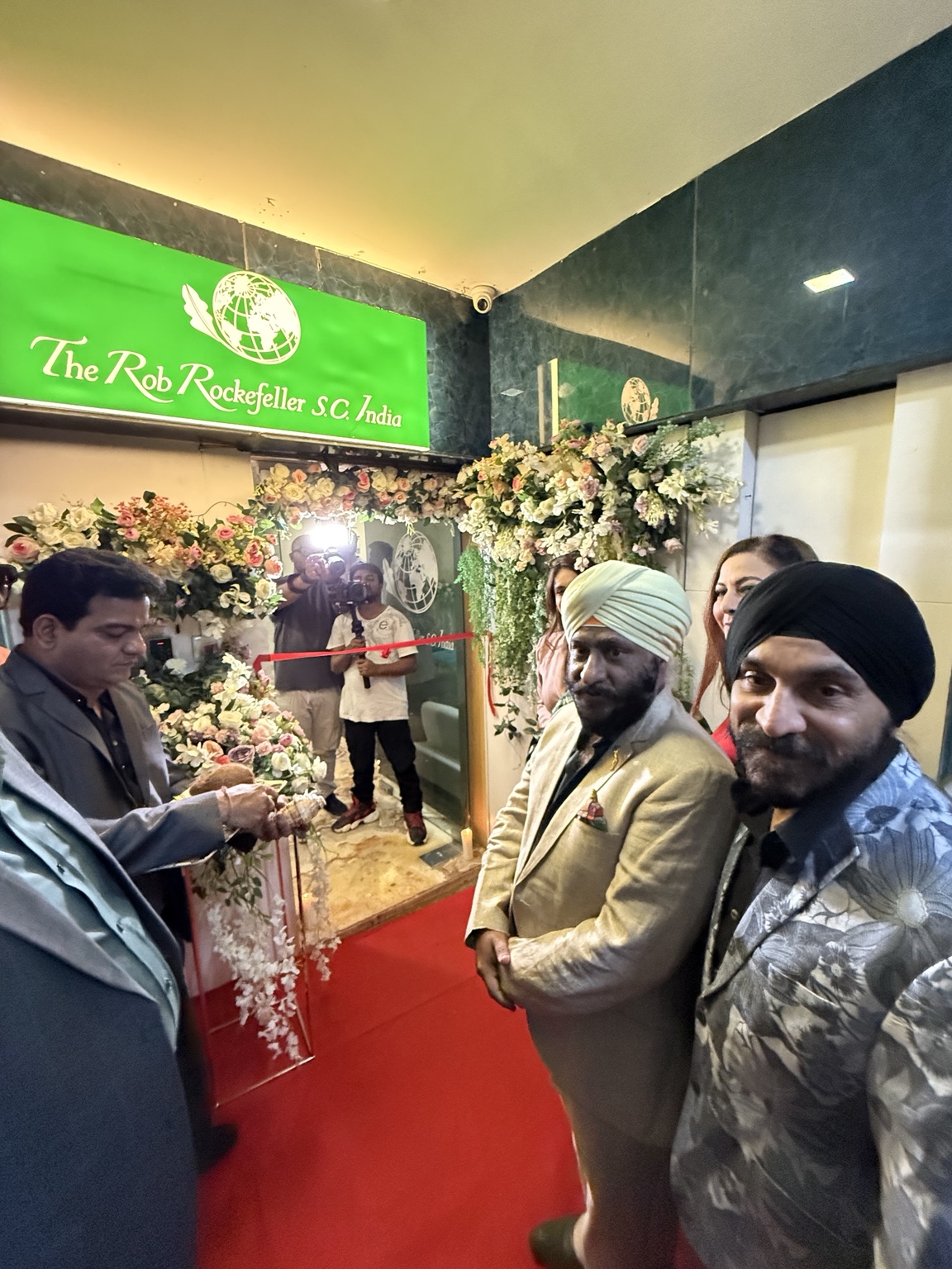 Guests at the flower-decorated India Branch entrance with an inauguration ribbon