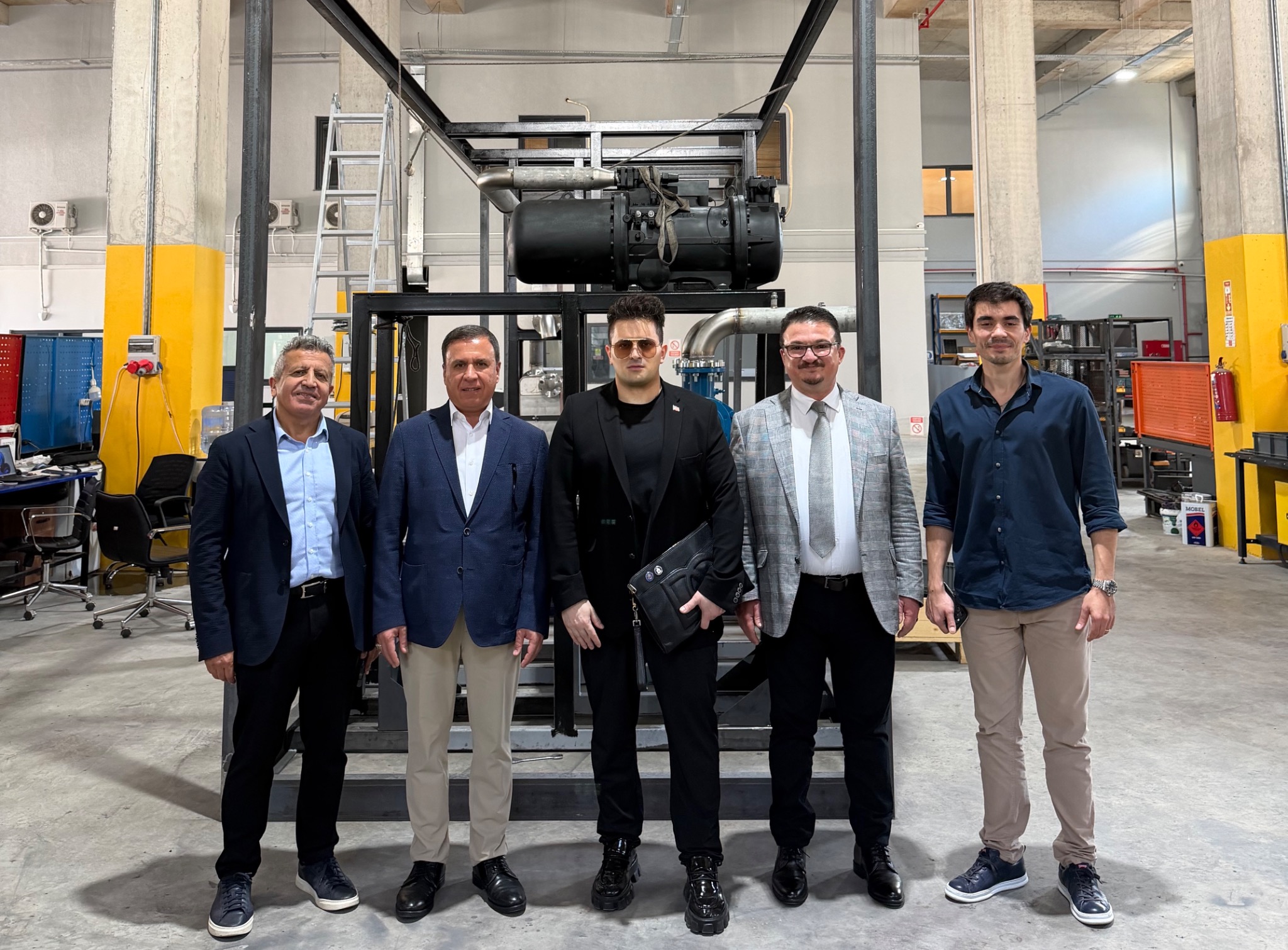 Members of the visiting delegation beside equipment under assembly in Bursa.