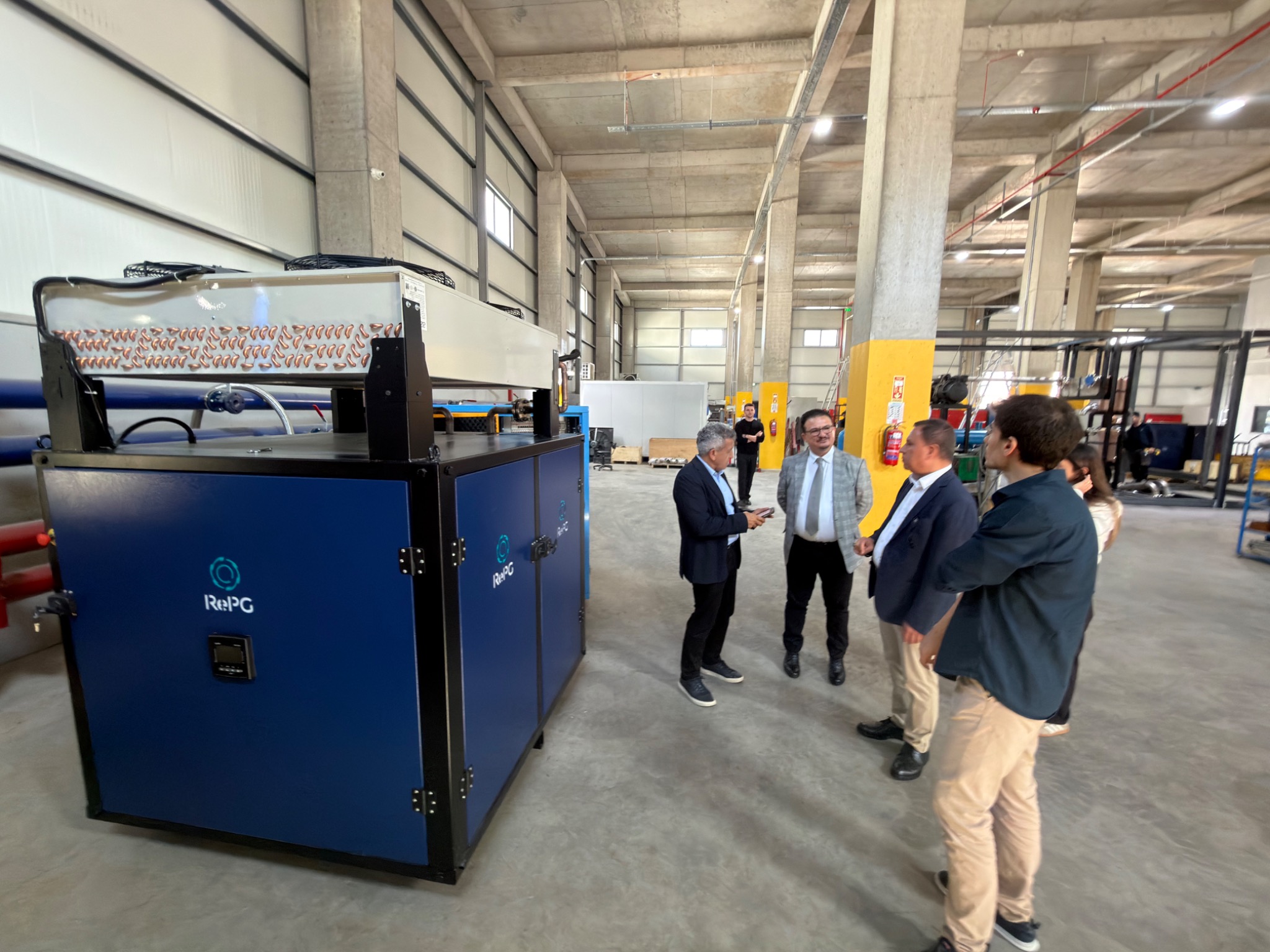 Technical discussion beside RePG equipment in the engineering workshop.