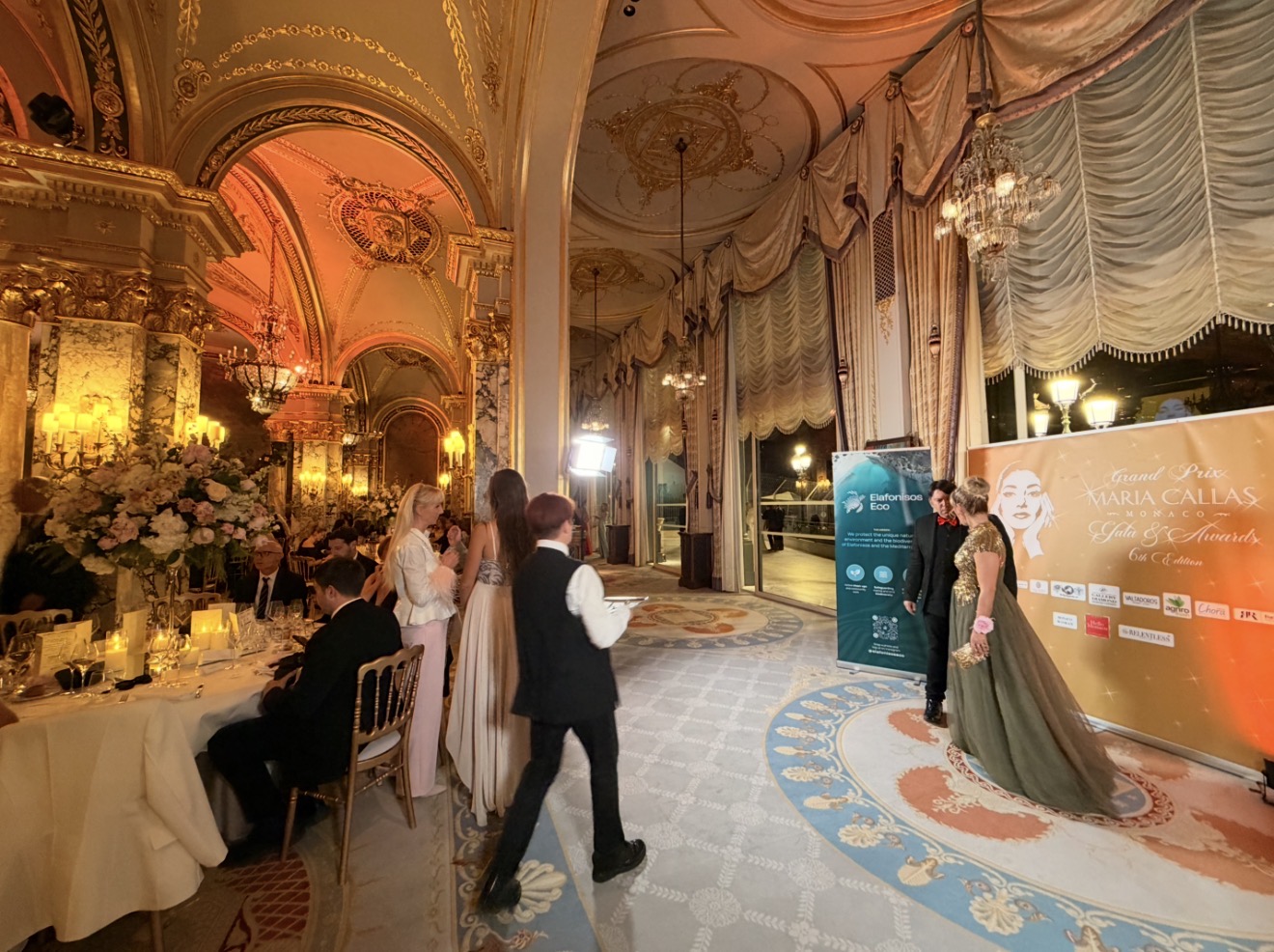 The original gala reception photograph supplied by Valentino, showing guests, the floral tables and the official sixth-edition photocall