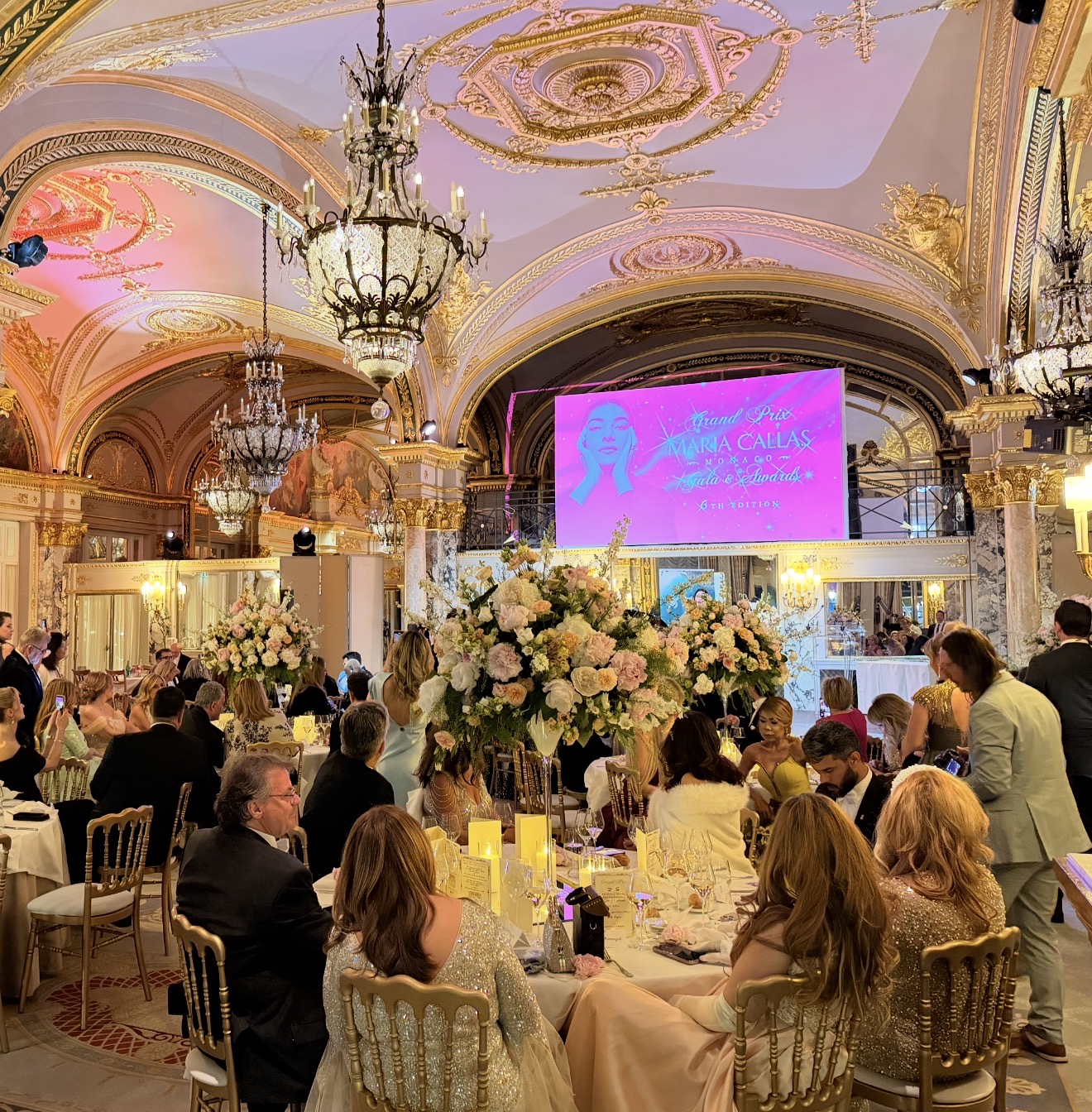The floral tables, chandeliers and Maria Callas Monaco screen inside the Salle Empire