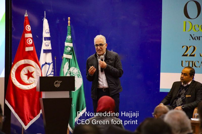 A speaker using a handheld microphone beside the forum lectern