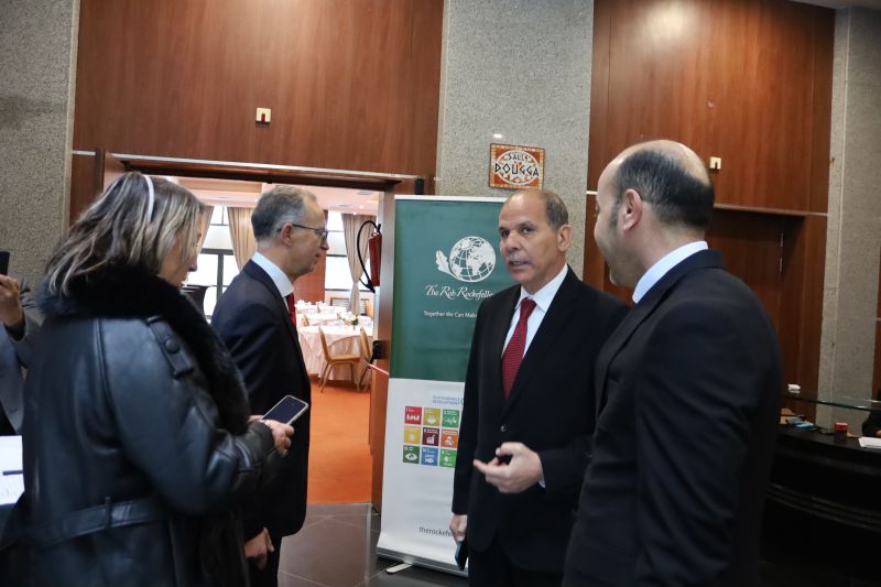 A group of participants talking beside an RRSC display in the reception area