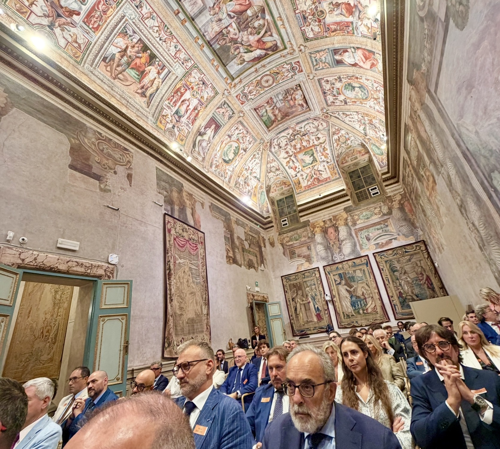 Audience beneath the decorated ceiling of Sala Zuccari